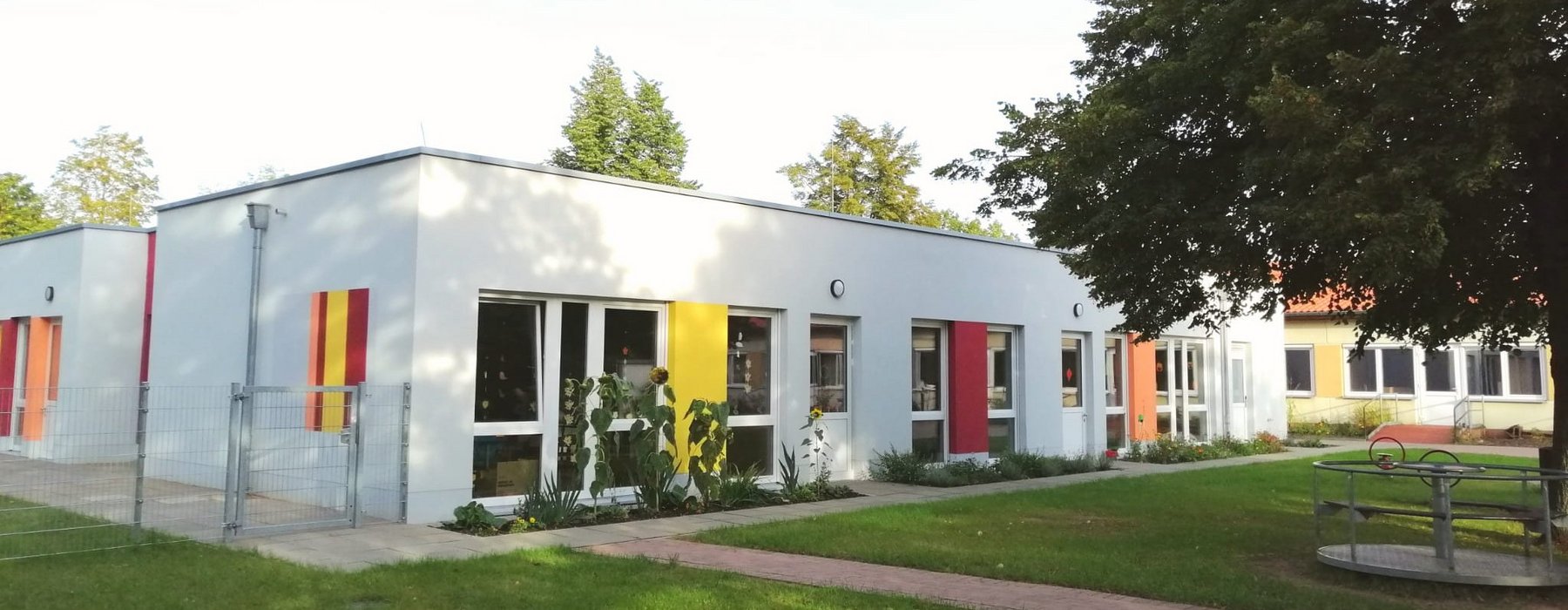 Eine außen Ansicht der Weinbergschule wo man die Farbig angemalten Rechtecken stellen an der Schulaußenwand erkennen kann