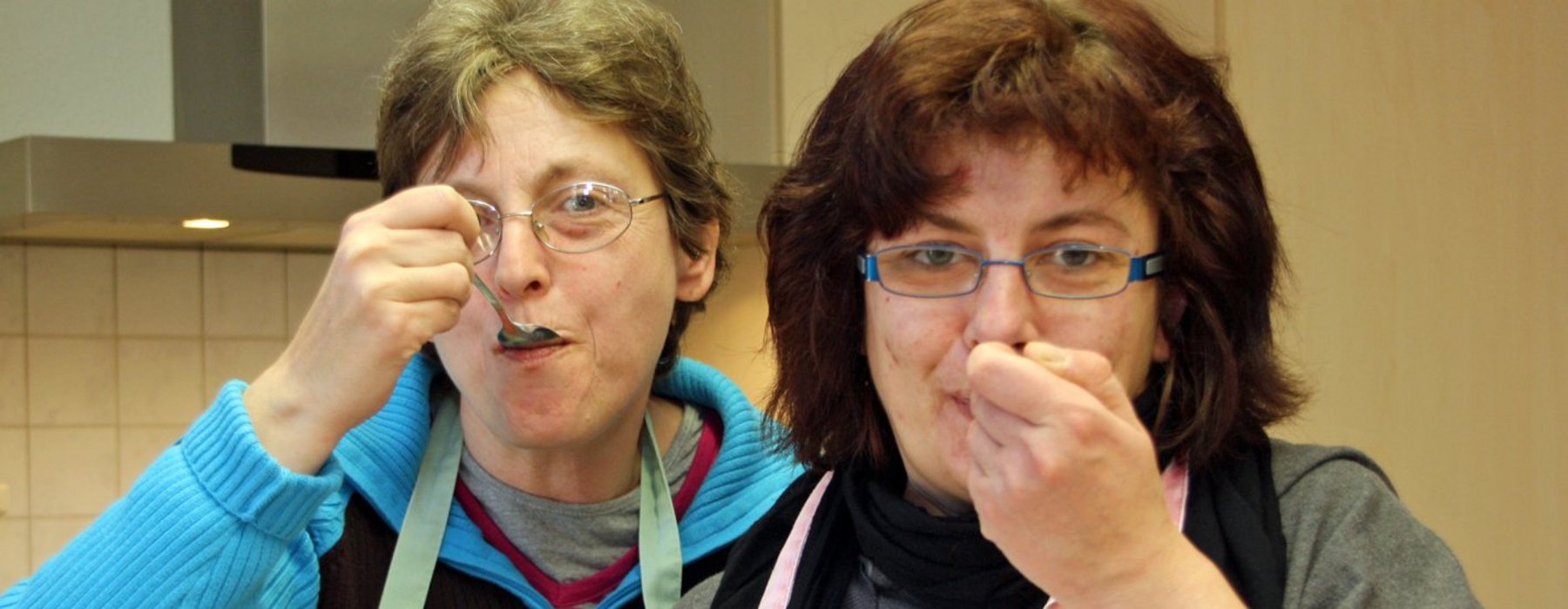 Zwei Erwachsene Probieren etwas von Löffeln